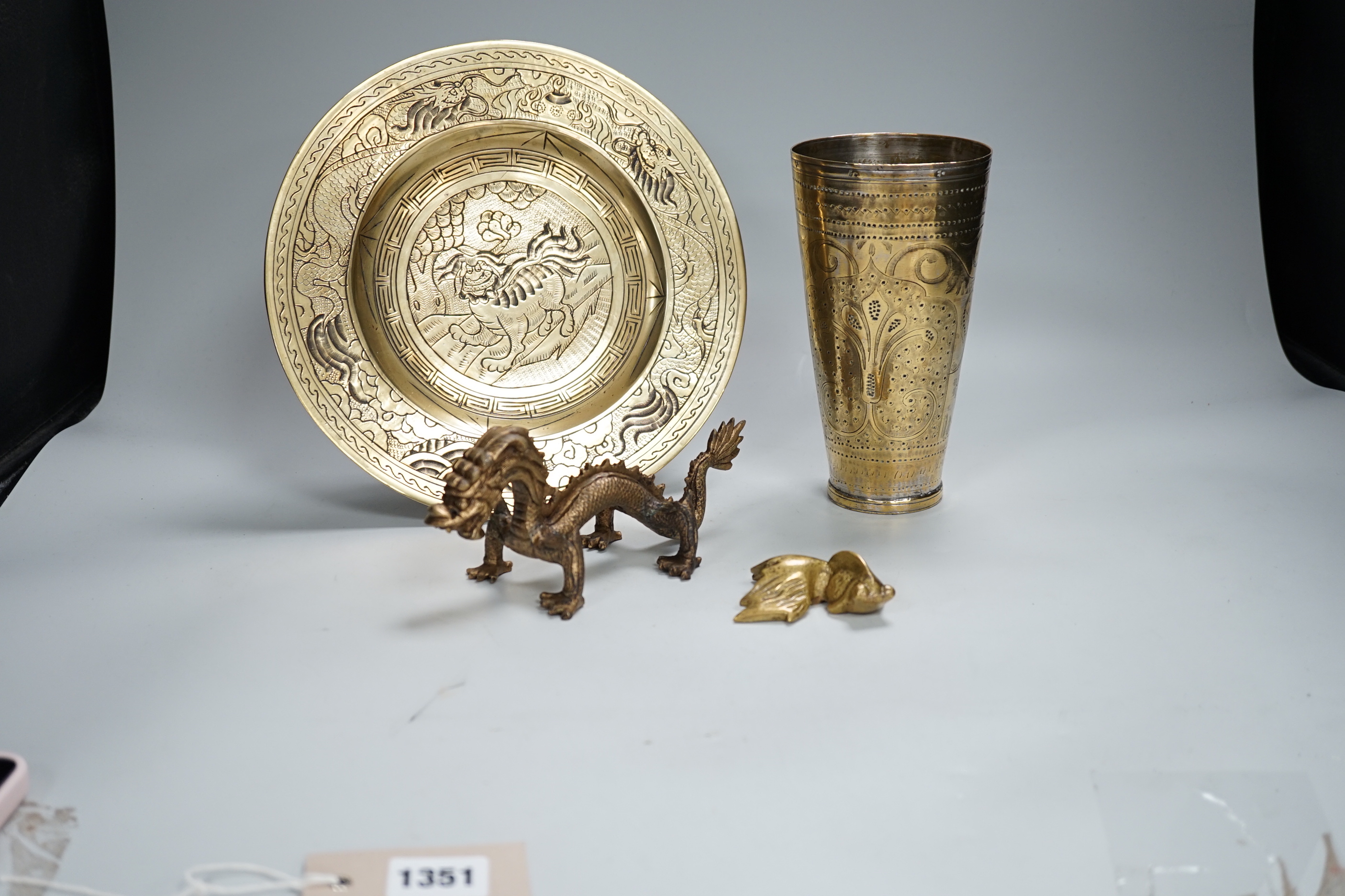 A Chinese engraved brass plate, large engraved beaker, koi fish and a dragon, the largest 24cm in diameter